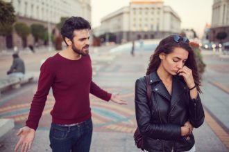A couple arguing in a city square