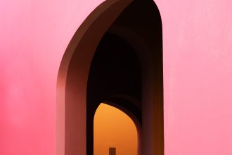 a large pink archway reveals an orange wall in the distance