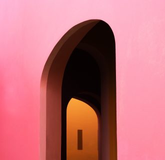 a large pink archway reveals an orange wall in the distance