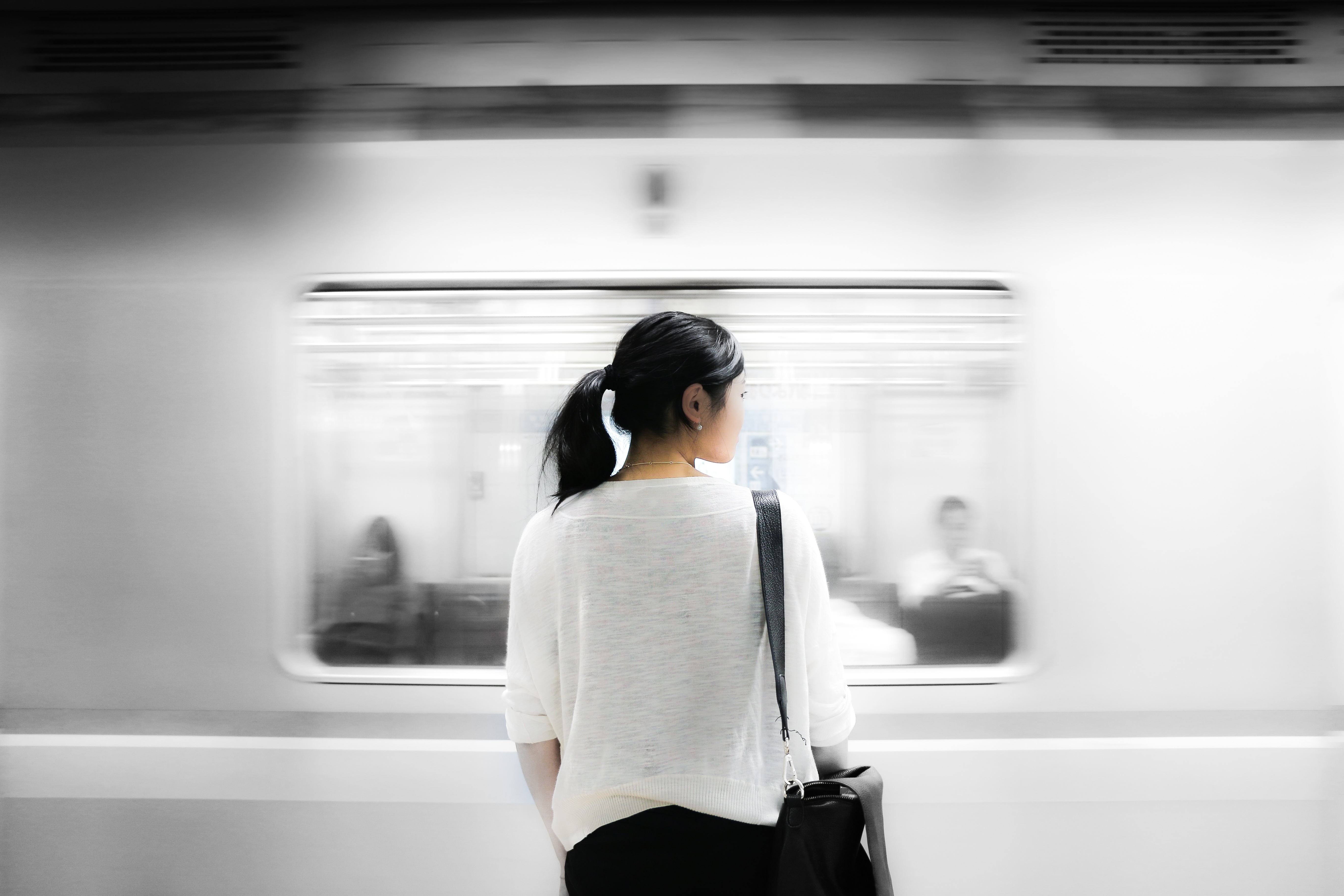 woman on train platform as subway rushes by