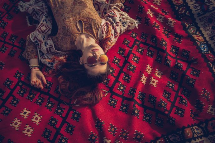 One woman, hippie lying on a blanket, enjoying alone.