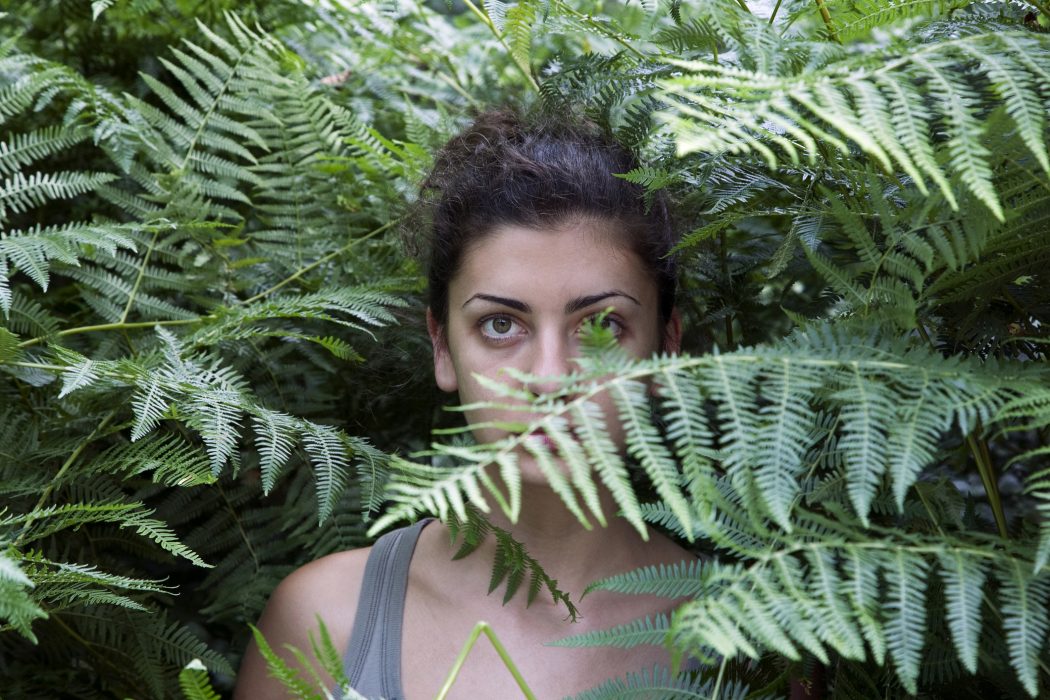 Young woman among ferns