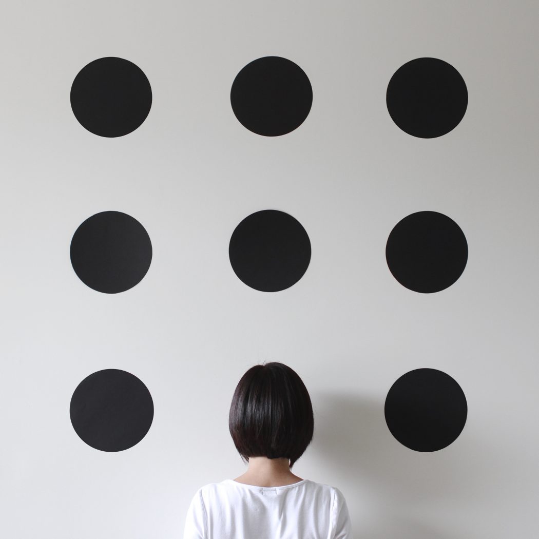 Woman facing a wall with dots