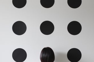 Woman facing a wall with dots