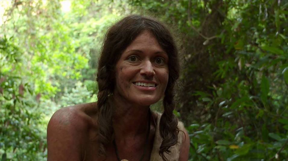 Tara smiles in the jungle, hair unbrushed and dirt on her face