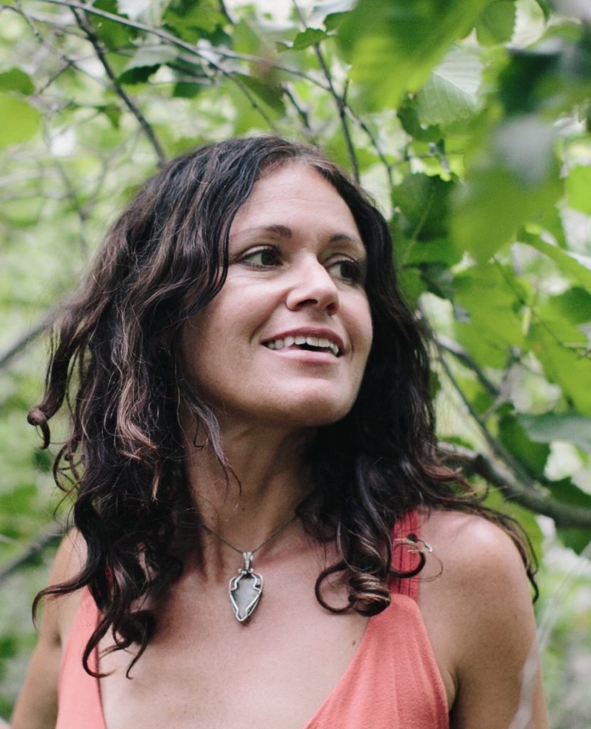 Tara smiles in front of a tree