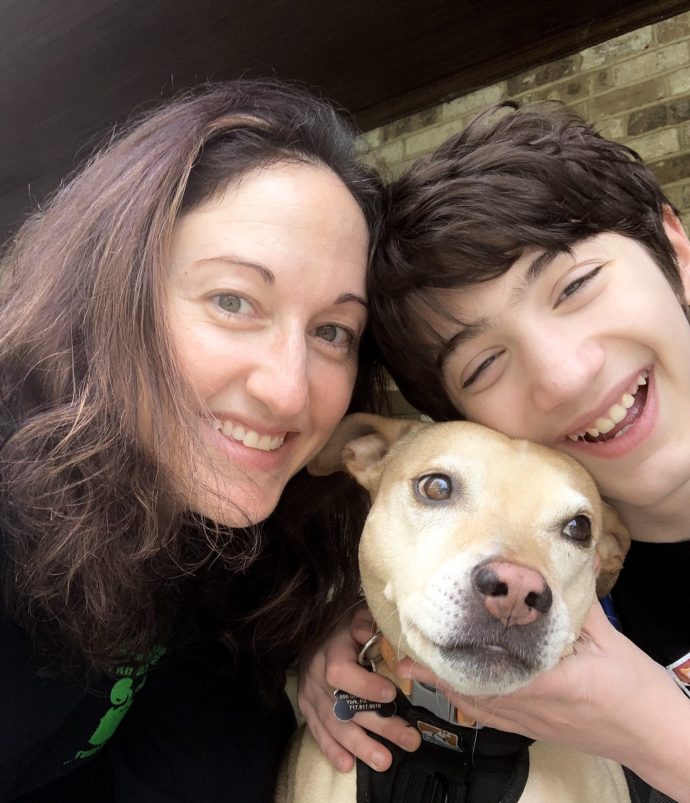 Liz smiling with son and dog